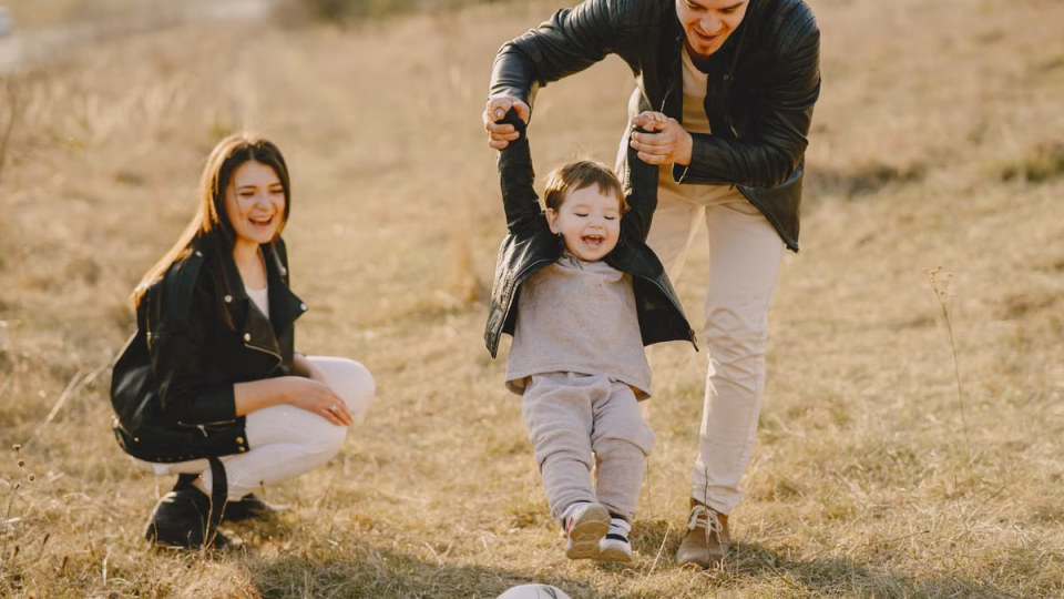 Family enjoying playful soccer game outdoors, capturing joyful moments.